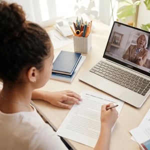 A student writing her college essay with the support of her College Essay Coach