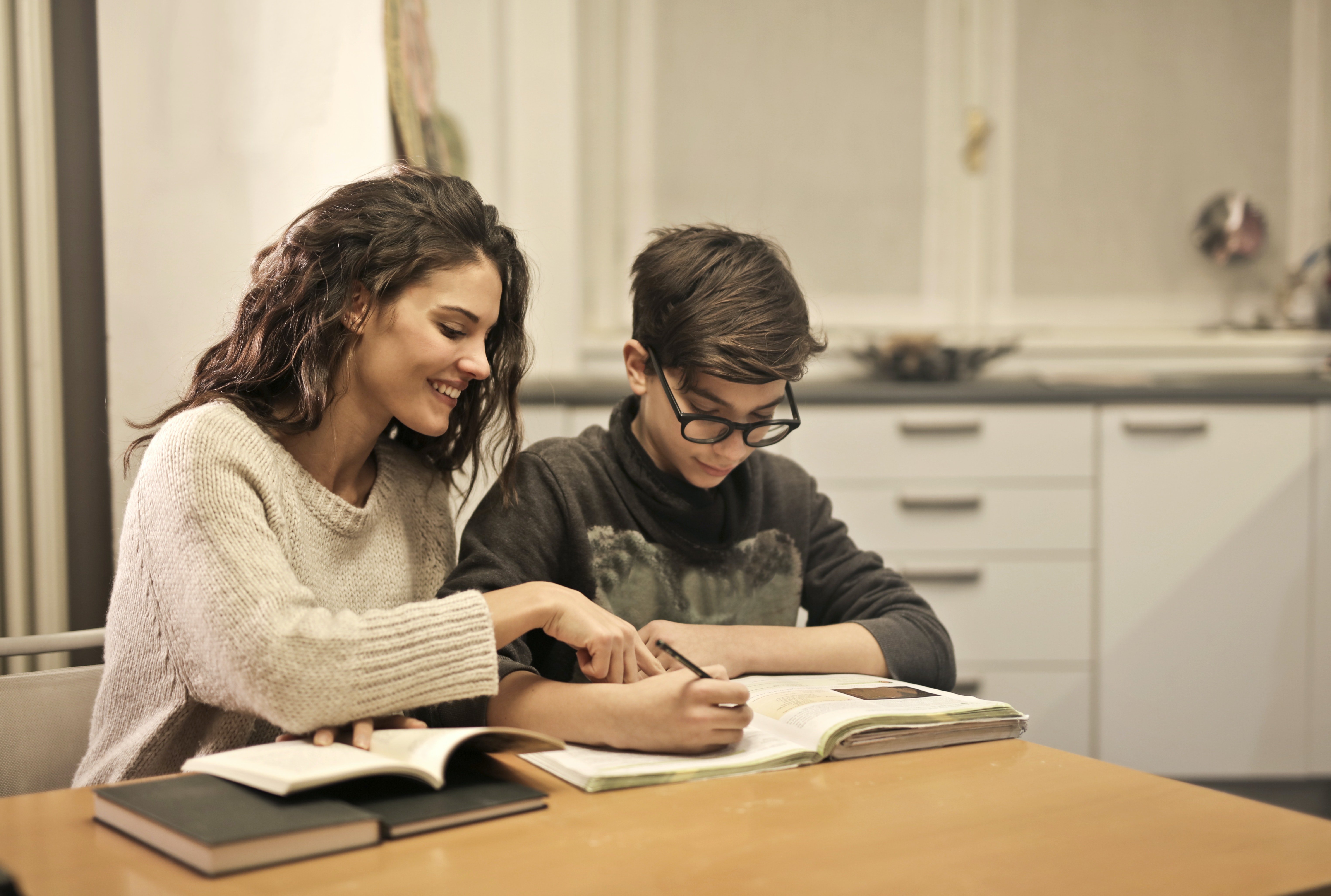 Homeschooled student being supported by his mother on his studies.